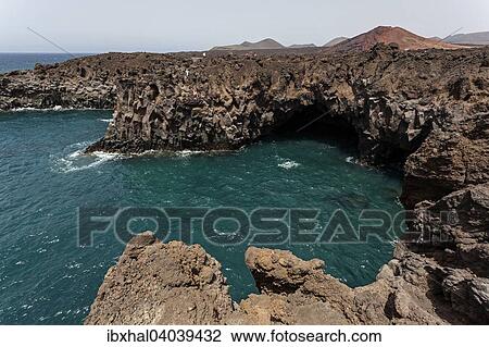 "Lava rocks, Los Hervideros, in back Montana de la Vieja Gabriela and Montanas del Fuego de Timanfaya, Lanzarote, Canary Islands, Spain, Europe" View Large Photo Image Stock Image - "Lava rocks, Los Hervideros, in back Montana de la Vieja Gabriela and Montanas del Fuego de Timanfaya, Lanzarote, Canary Islands, Spain, Europe". Fotosearch