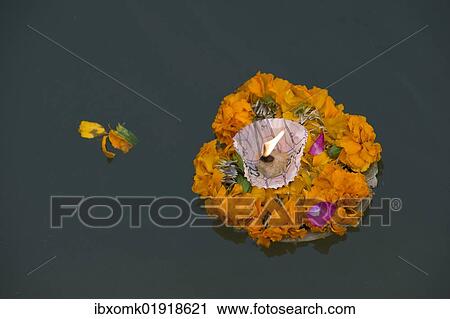 Stock Image - "Leaf bowl with flowers and oil lamp floating on the Ganges river, Varanasi, Uttar Pradesh, India, Asia". Fotosearch