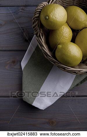 Lemons in a basket on a kitchen towel on a wooden background View Large Photo Image Stock Image - Lemons in a basket on a kitchen towel on a wooden background. Fotosearch
