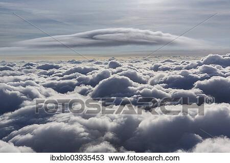 "Lenticular cloud, Cumulus lenticularis, above the top layer of clouds, North Rhine-Westphalia, Germany, Europe" View Large Photo Image Stock Image - "Lenticular cloud, Cumulus lenticularis, above the top layer of clouds, North Rhine-Westphalia, Germany, Europe". Fotosearch