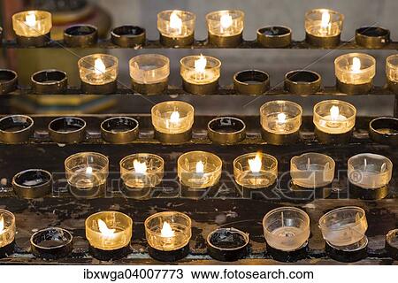 Stock Image - "Lighted votive candles in a church, Munich, Upper Bavaria, Bavaria, Germany, Europe". Fotosearch