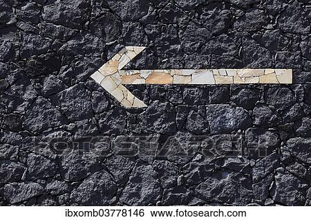 "Limestone arrow pointing to the left, on a dry stone wall made of volcanic rock" View Large Photo Image Stock Photograph - "Limestone arrow pointing to the left, on a dry stone wall made of volcanic rock". Fotosearch