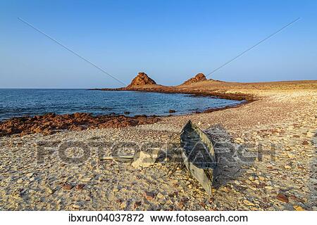 Stock Image - "Little canoe on the rocky beach, Dihamri, island of Socotra, Yemen, Asia". Fotosearch