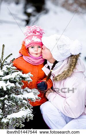 Picture - Little girl and her mother in the snowy woods. Fotosearch