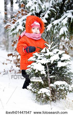 Little girl in a snowy forest View Large Photo Image Stock Photo - Little girl in a snowy forest. Fotosearch