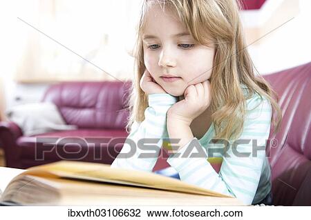 Stock Image - "Little girl reading at home, Germany, Europe". Fotosearch