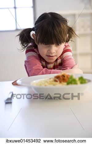 Little girl sitting listlessly in front of a plate of spaghetti View Large Photo Image Stock Image - Little girl sitting listlessly in front of a plate of spaghetti. Fotosearch