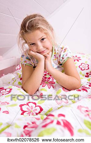 Stock Photograph - Little girl waking up in bed. Fotosearch
