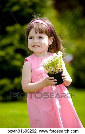 Stock Image - Little girl with flower pot. Fotosearch