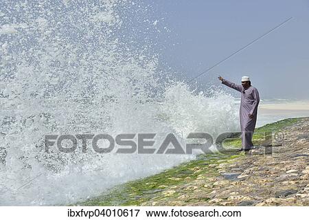 "Local man watching the surf at the corniche of Salalah during the monsoon season, or Khareef season, Salalah, Dhofar region, Orient, Oman, Asia" View Large Photo Image Stock Photo - "Local man watching the surf at the corniche of Salalah during the monsoon season, or Khareef season, Salalah, Dhofar region, Orient, Oman, Asia". Fotosearch