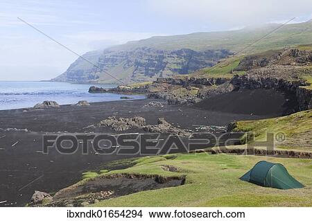Picture - "Lonely tent on a meadow in the early morning fog, Osthoefn, Heradsfloi bay, Greenland Sea, Atlantic coast, Iceland, Europe". Fotosearch