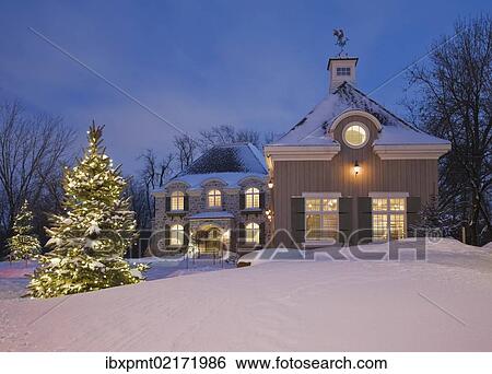"Luxurious residential cottage style home with illuminated evergreen trees at dusk in winter, Quebec, Canada, North America" View Large Photo Image Stock Photograph - "Luxurious residential cottage style home with illuminated evergreen trees at dusk in winter, Quebec, Canada, North America". Fotosearch