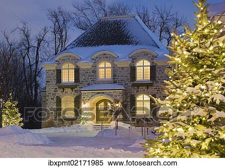 "Luxurious residential cottage style home with illuminated evergreen trees at dusk in winter, Quebec, Canada, North America" View Large Photo Image Stock Photography - "Luxurious residential cottage style home with illuminated evergreen trees at dusk in winter, Quebec, Canada, North America". Fotosearch