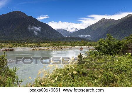 Stock Image - "Mahitahi River with views towards the Bannock Brea Range and the snow-capped Mount Stratford, 1977m, Southern Alps, Bruce Bay, West Coast Region, New Zealand, Oceania". Fotosearch