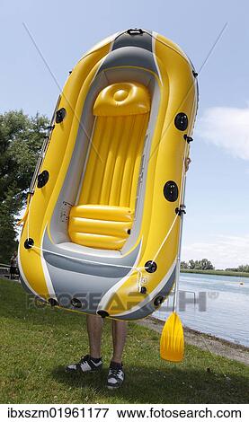 "Man carrying a rubber dinghy getting ready for launching it into the water, transition of Lake Constance into Seerhein river and Untersee lake, Taegerwilen, Switzerland, Europe" View Large Photo Image Stock Photo - "Man carrying a rubber dinghy getting ready for launching it into the water, transition of Lake Constance into Seerhein river and Untersee lake, Taegerwilen, Switzerland, Europe". Fotosearch