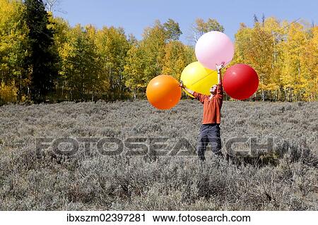 "Man carrying huge balloons, landscape in fall, Utah, USA" View Large Photo Image Stock Image - "Man carrying huge balloons, landscape in fall, Utah, USA". Fotosearch