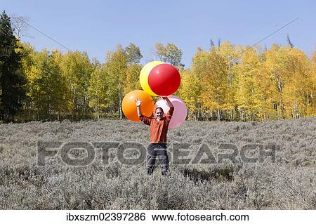 "Man carrying huge balloons, landscape in fall, Utah, USA" View Large Photo Image Stock Photograph - "Man carrying huge balloons, landscape in fall, Utah, USA". Fotosearch