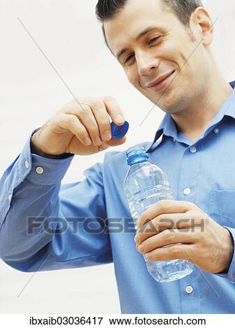 Man opening a water bottle View Large Photo Image Stock Photo - Man opening a water bottle. Fotosearch