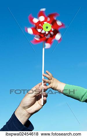 "Man passing a wind wheel to a child, symbolic image for environmental education, alternative energy and sustainability" View Large Photo Image Stock Photo - "Man passing a wind wheel to a child, symbolic image for environmental education, alternative energy and sustainability". Fotosearch