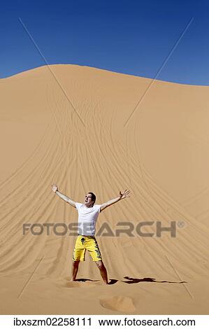 "Man raising his hands in the desert, Coral Pink Sand Dunes State Park, near Kanab, Utah, USA" View Large Photo Image Stock Image - "Man raising his hands in the desert, Coral Pink Sand Dunes State Park, near Kanab, Utah, USA". Fotosearch