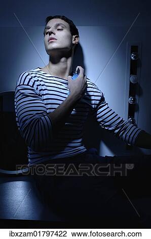 "Man wearing a striped T-shirt in a bathroom, spraying on perfume" View Large Photo Image Stock Image - "Man wearing a striped T-shirt in a bathroom, spraying on perfume". Fotosearch