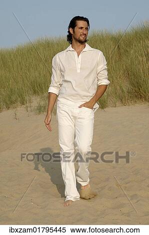 Man wearing white clothes walking in the dunes on the beach View Large Photo Image Stock Photography - Man wearing white clothes walking in the dunes on the beach. Fotosearch