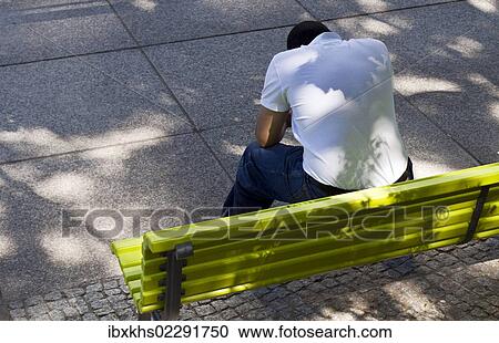 "Man with bowed head sitting on a green park bench, Berlin, Germany, Europe" View Large Photo Image Stock Image - "Man with bowed head sitting on a green park bench, Berlin, Germany, Europe". Fotosearch