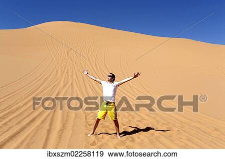 "Man with outstretched arms in the desert, Coral Pink Sand Dunes State Park, near Kanab, Utah, USA" View Large Photo Image Stock Photo - "Man with outstretched arms in the desert, Coral Pink Sand Dunes State Park, near Kanab, Utah, USA". Fotosearch