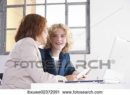 Manager working in an office with a trainee at the computer View Large Photo Image Stock Image - Manager working in an office with a trainee at the computer. Fotosearch