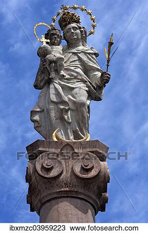 Stock Image - "Marian column against a cloudy sky, Murnau, Upper Bavaria, Bavaria, Germany, Europe". Fotosearch