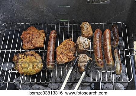 Stock Photograph - "Meat and sausages or bratwursts on a grill, Germany, Europe". Fotosearch