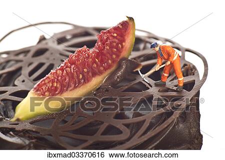 Stock Photograph - Miniature figure of a construction worker on a chocolate cupcake. Fotosearch