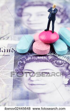Miniature figurine of businessman standing on medical pills on pound banknote View Large Photo Image Stock Photo - Miniature figurine of businessman standing on medical pills on pound banknote. Fotosearch