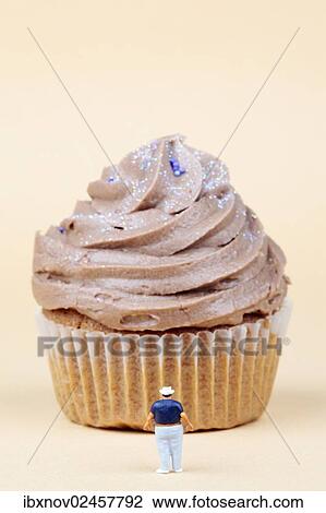 Miniature figurine standing in front of muffin View Large Photo Image Stock Image - Miniature figurine standing in front of muffin. Fotosearch