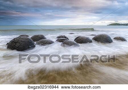 Picture - "Moeraki Boulders, geological feature, round rock balls, washed by the waves of the surf at high tide, Coastal Otago, Moeraki, South Island, New Zealand, Oceania". Fotosearch