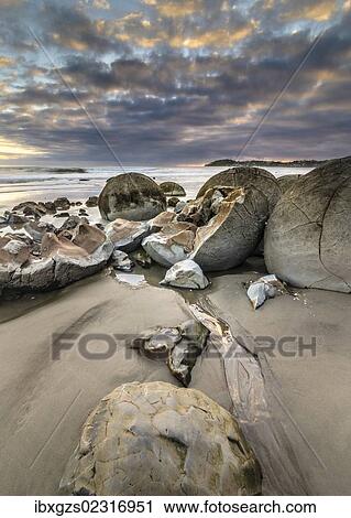 Stock Image - "Moeraki Boulders, geological feature, round rock balls, some fragments lying broken in ruins on the beach, Coastal Otago, Moeraki, South Island, New Zealand, Oceania". Fotosearch