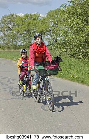 Stock Photo - Mother and son with their dog on a cycling tour. Fotosearch