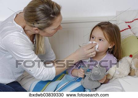 "Mother taking care of her sick daughter, wiping the girl's nose, girl lying in bed" View Large Photo Image Stock Image - "Mother taking care of her sick daughter, wiping the girl's nose, girl lying in bed". Fotosearch