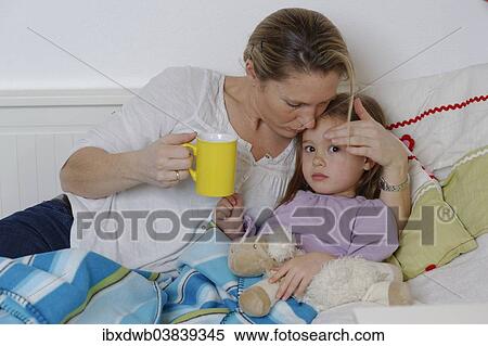 "Mother taking care of her sick daughter, dispensing hot tea, girl lying in bed" View Large Photo Image Stock Photography - "Mother taking care of her sick daughter, dispensing hot tea, girl lying in bed". Fotosearch