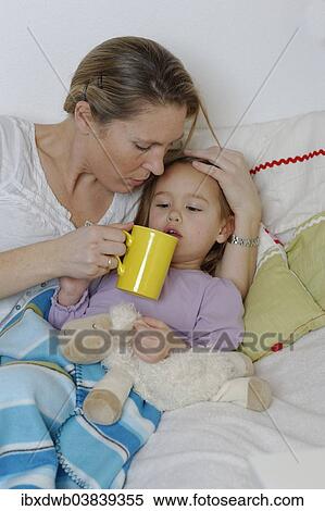 "Mother taking care of her sick daughter, dispensing hot tea, girl lying in bed" View Large Photo Image Stock Photography - "Mother taking care of her sick daughter, dispensing hot tea, girl lying in bed". Fotosearch