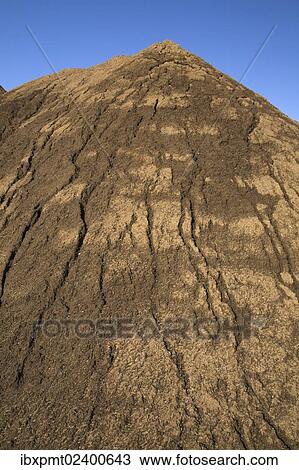 Stock Image - "Mound of sand in a commercial sandpit after a heavy rainfall, Quebec, Canada, North America". Fotosearch