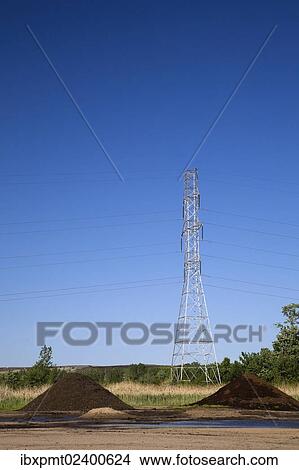 Picture - "Mounds of topsoil and a hydro electricity transmission tower in a commercial sandpit, Quebec, Canada, North America". Fotosearch