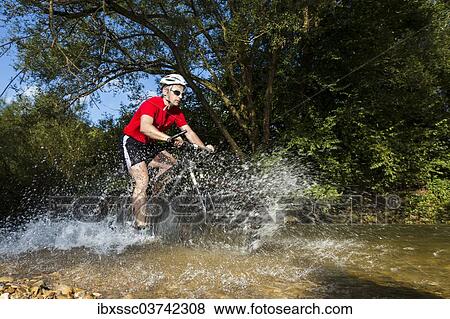 "Mountain biker crossing a stream, Winterbach, Baden-Wurttemberg, Germany, Europe" View Large Photo Image Stock Photo - "Mountain biker crossing a stream, Winterbach, Baden-Wurttemberg, Germany, Europe". Fotosearch