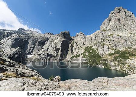 Stock Image - "Mountain lake Lac de Melo surrounded by cliffs, source of the Restonica river, Restonica mountain valley, Corte, Haute-Corse, Corsica, France, Europe". Fotosearch