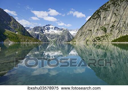 "Mountains around the Grimsel Pass are reflected in Gelmerstausee reservoir, Guttannen, Canton of Bern, Switzerland, Europe" View Large Photo Image Stock Photography - "Mountains around the Grimsel Pass are reflected in Gelmerstausee reservoir, Guttannen, Canton of Bern, Switzerland, Europe". Fotosearch