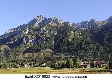 Stock Image - "Nesselwaengle, Tannheimer Tal valley, Gimpel mountain on the left, and Kellenspitze or Koellenspitze mountain, Tannheim Mountains, Tyrol, Austria, Europe, PublicGround, Europe". Fotosearch