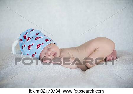 Picture - "Newborn baby, 3 weeks, sleeping, wearing a hat". Fotosearch