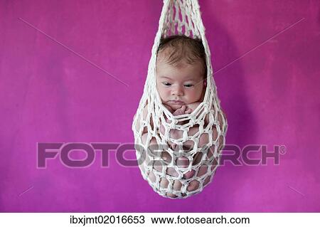 Stock Image - "Newborn baby, five days, suspended in a """"stork's bag""""". Fotosearch