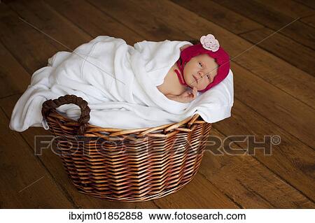"Newborn baby girl, two weeks old, with little red cap, lying in a basket" View Large Photo Image Stock Photo - "Newborn baby girl, two weeks old, with little red cap, lying in a basket". Fotosearch