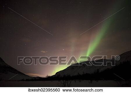 Stock Image - "Northern Lights over the Kattfjord pass in winter, Kvaloya, Tromso, Norway, Europe". Fotosearch